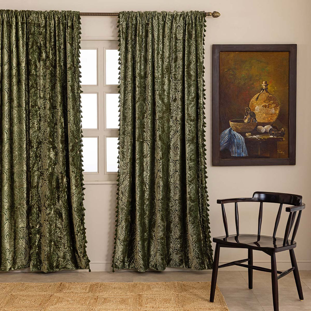 Moss green patterned velvet curtains with a chair and painting in a room.