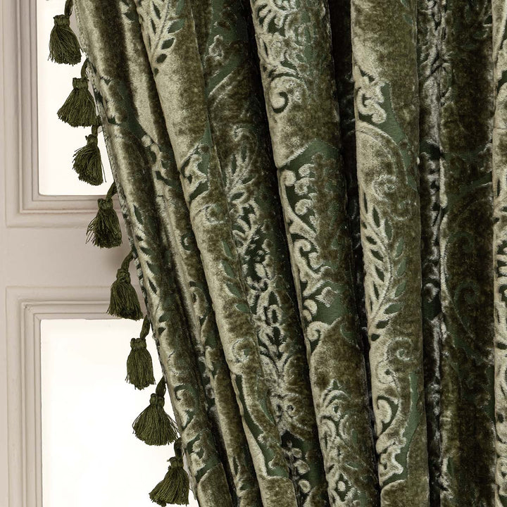 Decorative green curtain with intricate patterns and tassels